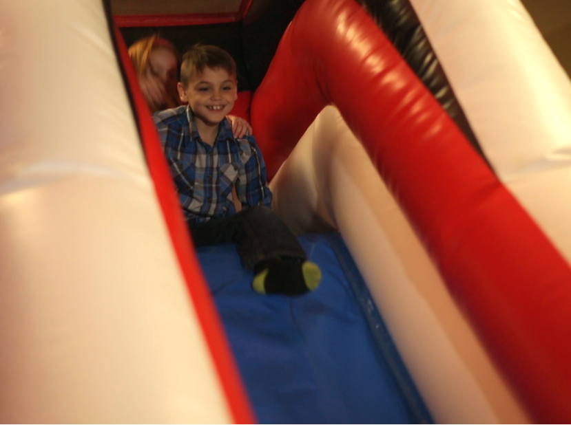 Kid Sliding Down Inflatable Bounce House