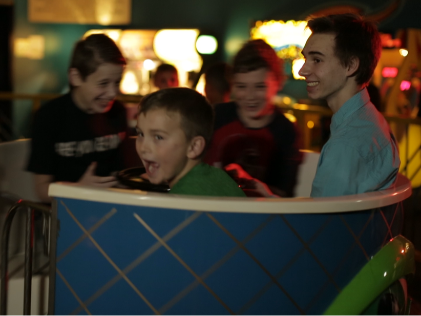 Group of Kids Laughing on Spinning Teacups Ride